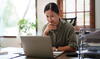 Woman thinking in sunny office